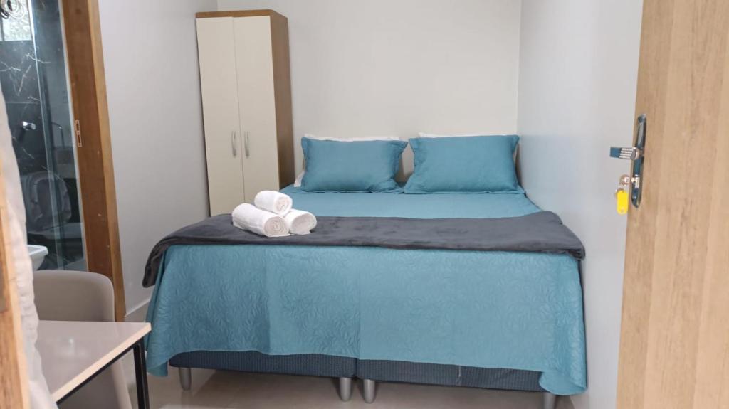 a bedroom with a blue bed with two towels on it at La Bella Luna Suítes in Alto Paraíso de Goiás