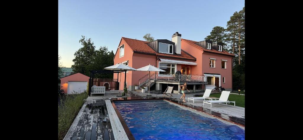 une maison avec une piscine en face d'une maison dans l'établissement Lidingö, à Lidingö