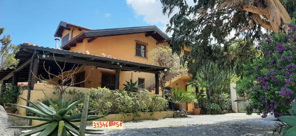 ein gelbes Haus mit Pflanzen davor in der Unterkunft Villa Panorama in Zambrone