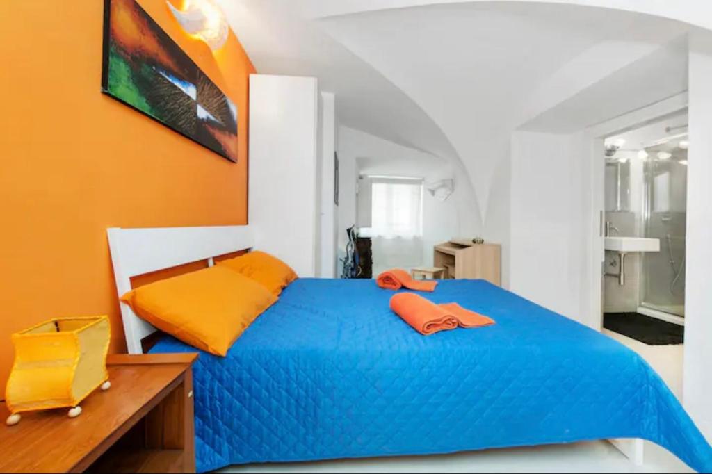 a bedroom with a blue bed and an orange wall at Fontana di Trevi Home in Rome