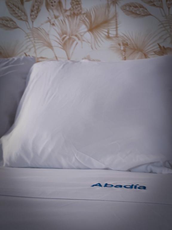 a white bed with a comforter on top of it at Apartamentos Abadía. in Corella
