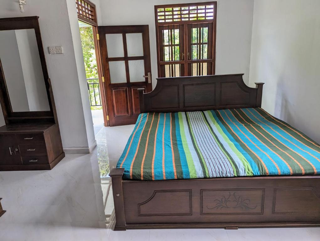 a bedroom with a bed with a colorful striped sheets at Uma Guest House in Kahawa