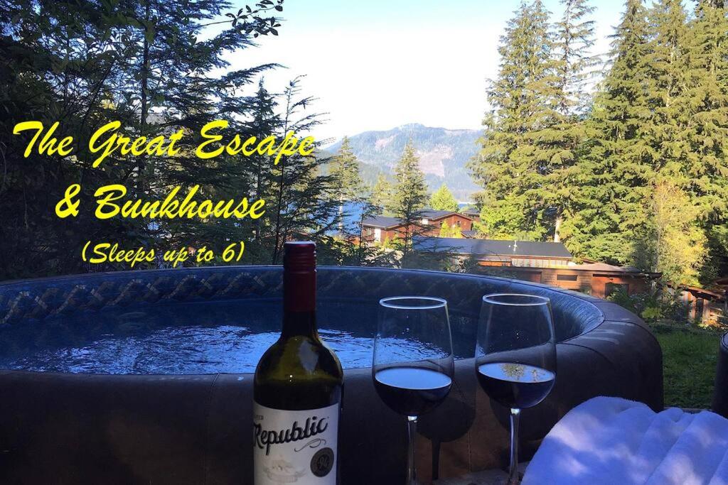 a bottle of wine and two glasses on a table at The Great Escape - Port Renfrew in Port Renfrew