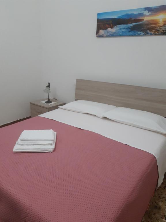 a bedroom with a large bed with a pink blanket at Da Gianni in Pantelleria