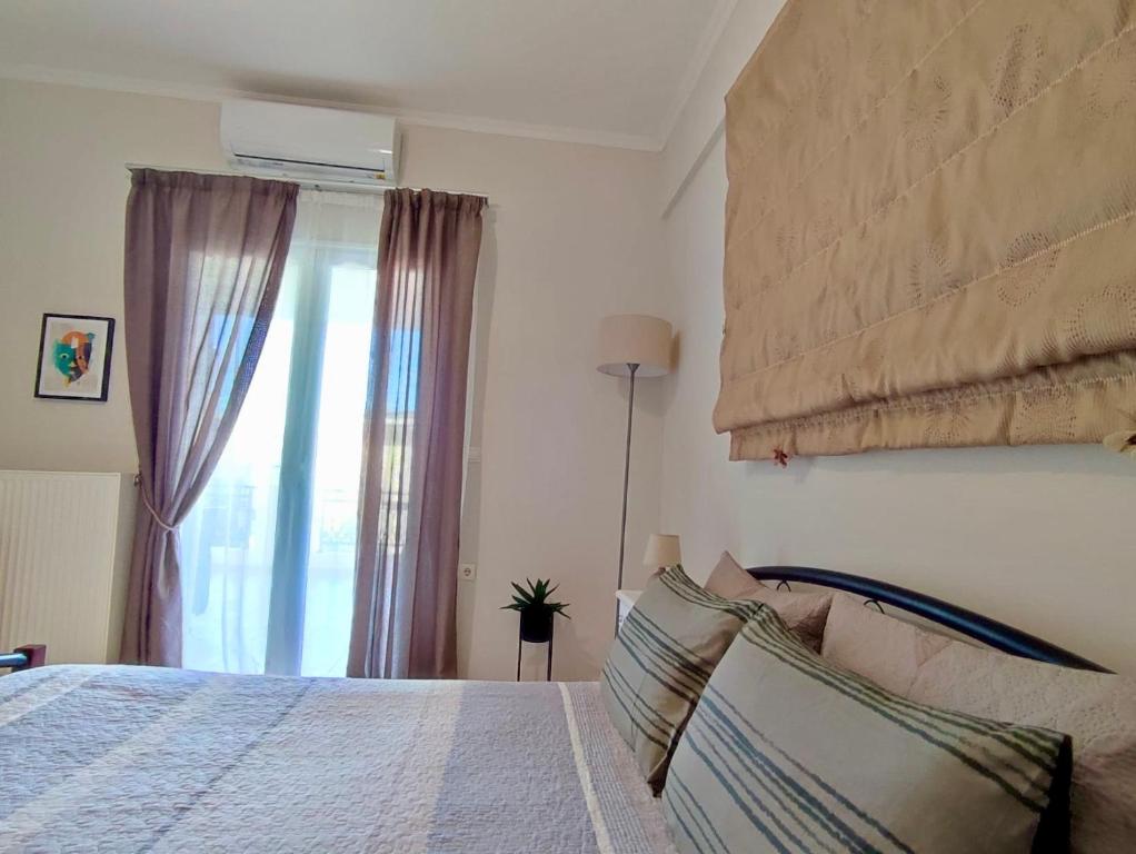 sypialnia z dużym łóżkiem i oknem w obiekcie Tzitzifianaki Cozy Apartment w Chanii