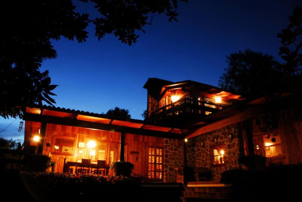 une maison éclairée la nuit avec des lumières dans l'établissement Casa Nora Malinalco: entire estate w/pool, 