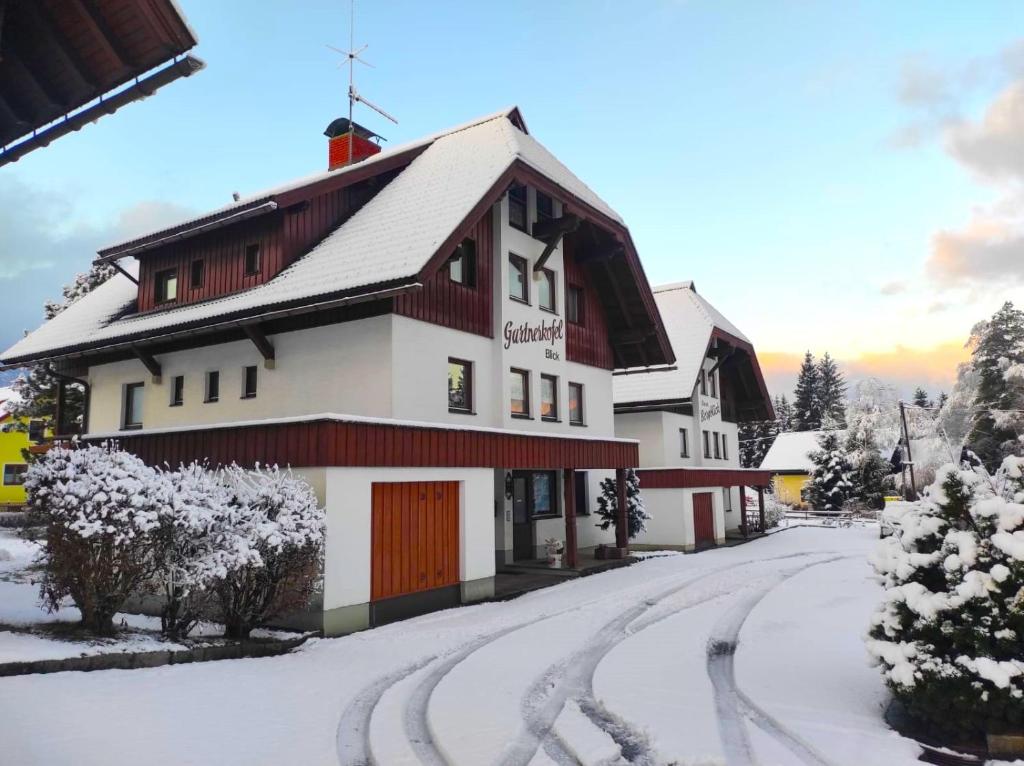 un edificio con neve sul terreno vicino a una strada di Alpenblick Apartment a Hermagor