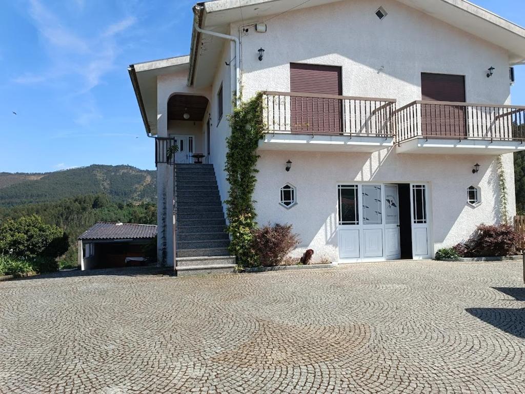 a large white house with a staircase in front of it at Abrigo das Andorinhas in Aveiro