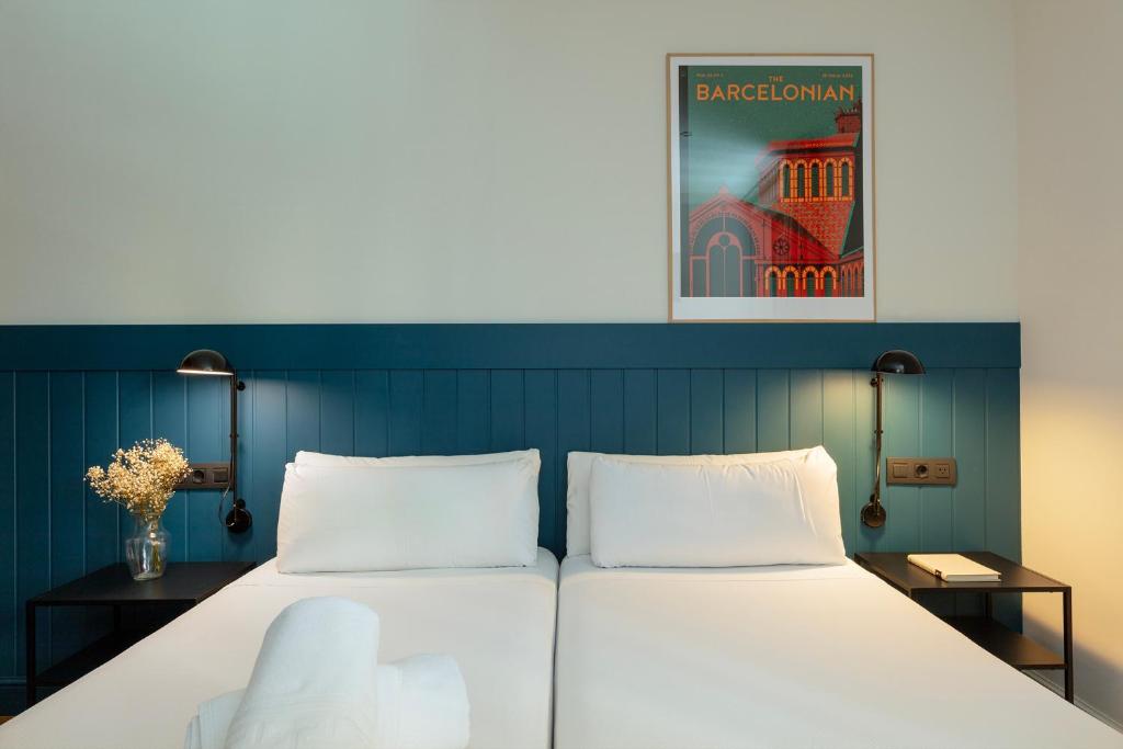 a bed with two white pillows in a room at Som Nit Port Vell in Barcelona