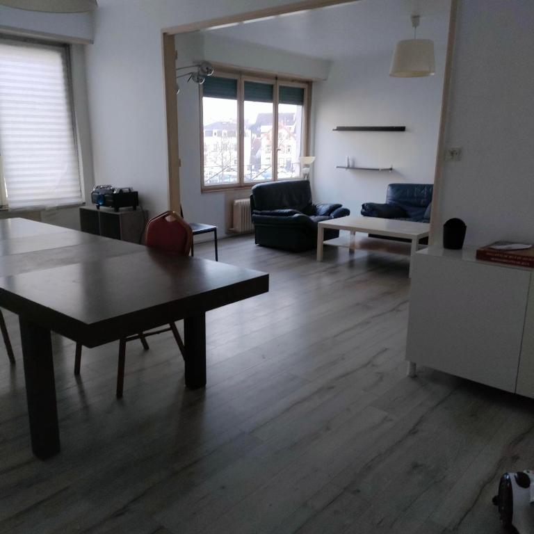 ein Wohnzimmer mit einem Tisch und einem Sofa in der Unterkunft 201Hervale in Straßburg