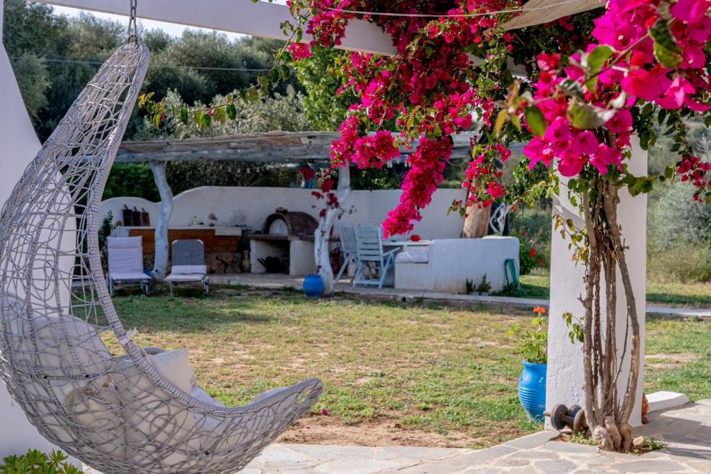 a hammock in the yard of a house with flowers at Summer House in Porto Heli