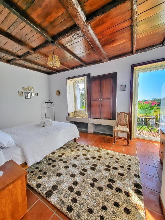 a bedroom with a bed and a large window at Torre de Santiago - Guest House in Vila Praia de Âncora