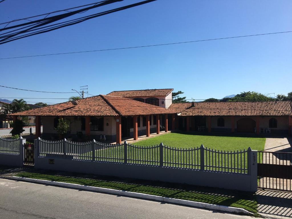 une maison avec une clôture blanche dans l'établissement CASARÃO CAPITAL DO SURF SAQUAREMA, à Saquarema