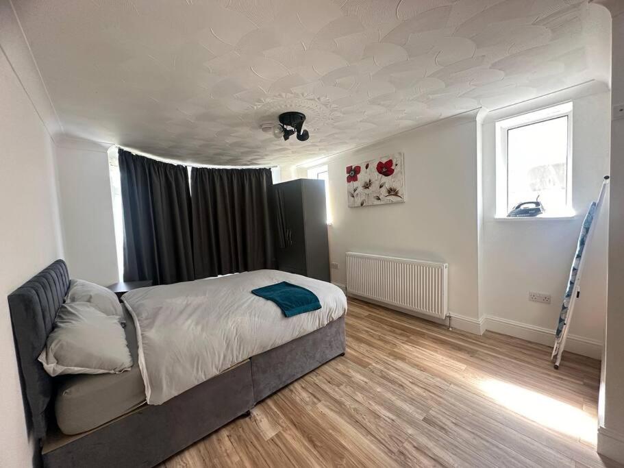 Deluxe Bungalow في Longham: غرفة نوم بسرير ونافذة