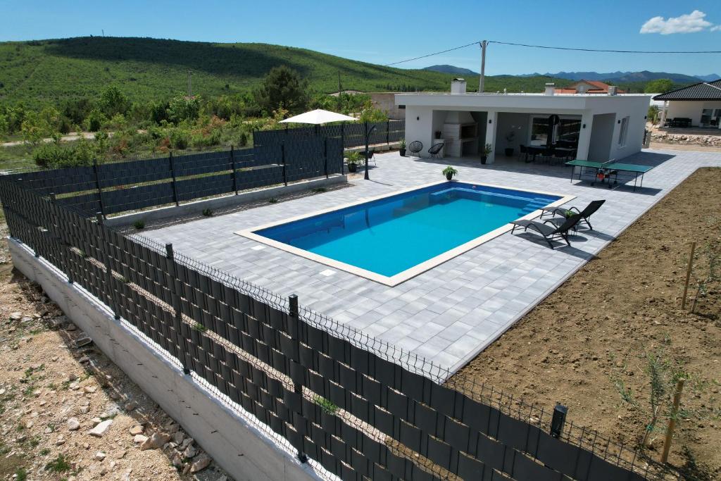 a backyard with a pool and a fence at Kuća za odmor 'Luca' in Ljubuški