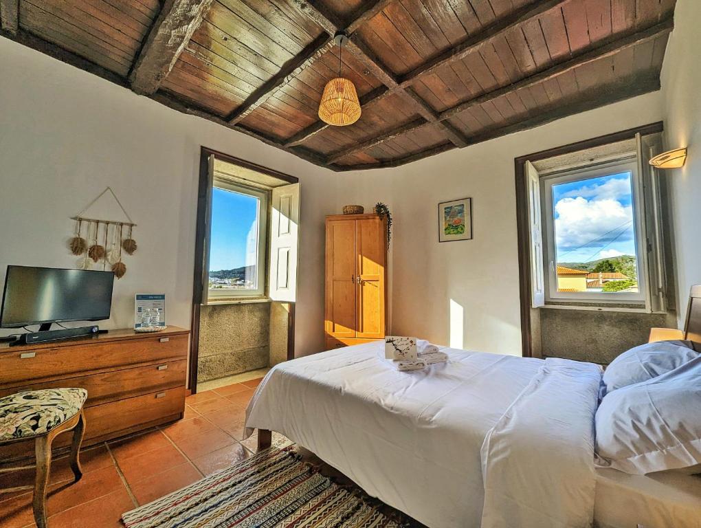 a bedroom with a bed and a flat screen tv at Torre de Santiago - Guest House in Vila Praia de Âncora