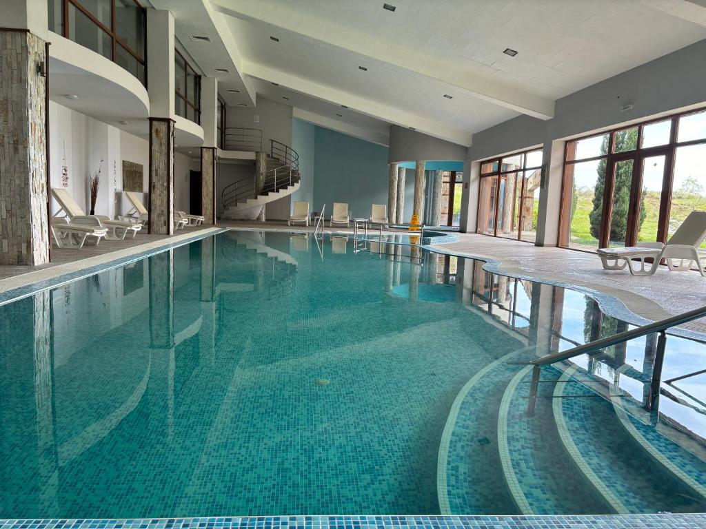 a large swimming pool with blue water in a building at Panorama Resort Bansko Wellness & Recreation in Bansko