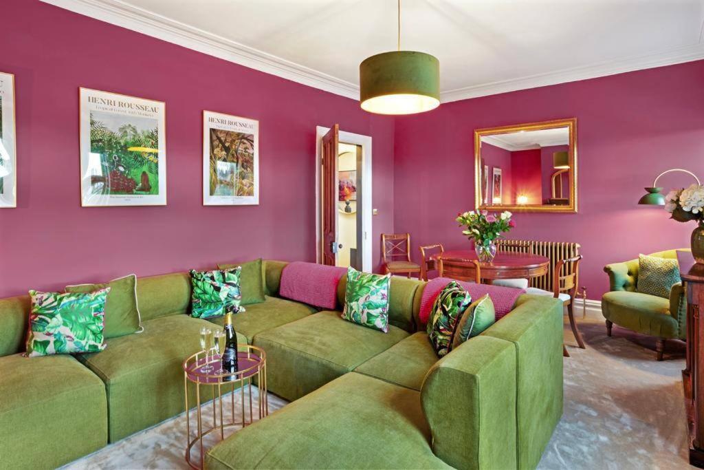 a living room with a green couch and purple walls at The Olive Suite - 3 bedroom - Free Parking in Harrogate