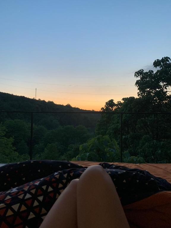 een vrouw die op een bed ligt en naar de zonsondergang kijkt bij Lima1 in Koetaisi