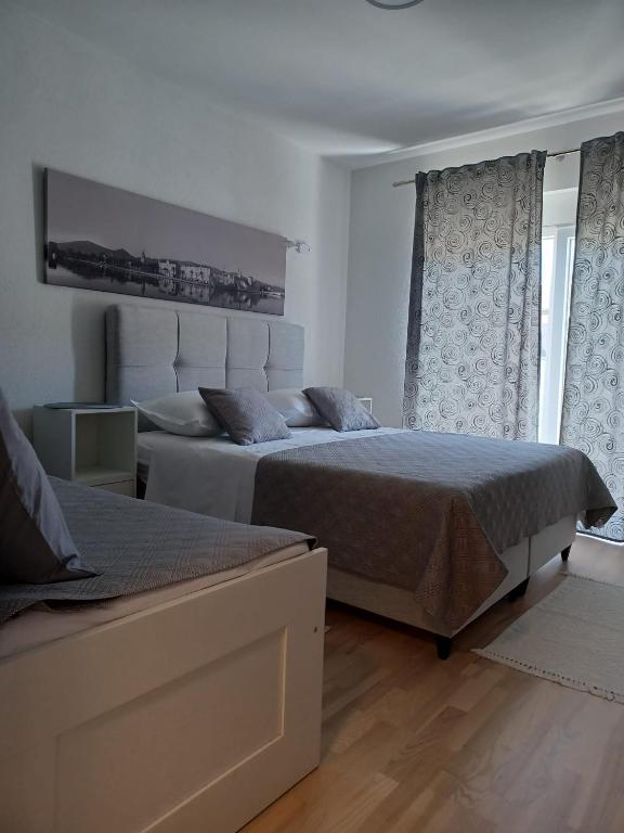a bedroom with two beds and a window at Studio apartman Marija in Trogir