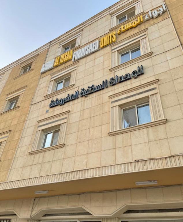 un edificio con un'insegna sul lato di اجواء المساء للشقق المخدومة a Riyad