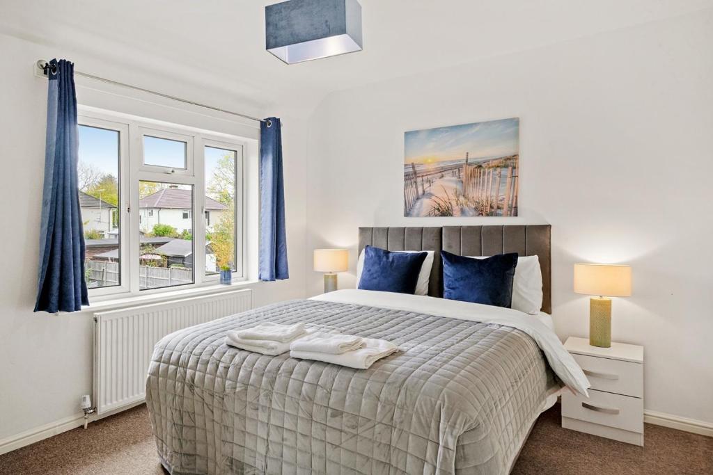 a bedroom with a large bed with blue curtains at No stress in Trumpington