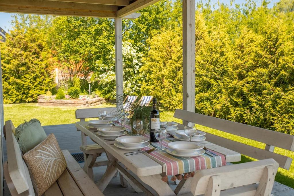 una mesa de madera con platos en el porche en Morska Polana, en Mielno