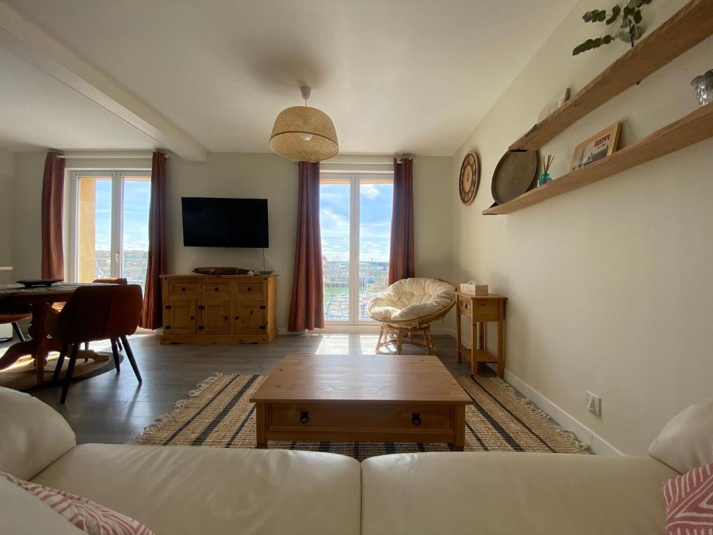 uma sala de estar com um sofá e uma mesa em Nouvel établissement avec ASCENSEUR, 3 appartements lumineux vue port avec balcon, 200m de la mer, service netflix, WIFI FIBRE, ménage inclus, serviettes et draps em Dieppe