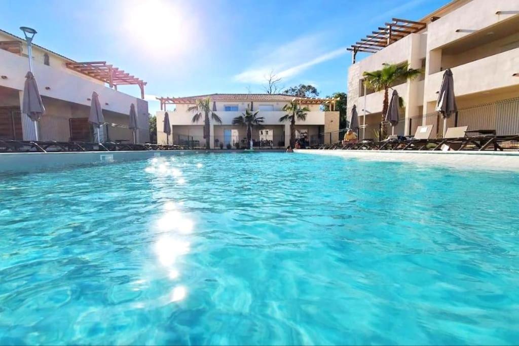 une piscine d'eau bleue dans un hôtel dans l'établissement Studio 2 personnes vue mer et pieds dans l'eau, à Linguizzetta