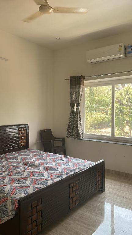 Sai udaipur home stay في أودايبور: غرفة نوم بسرير كبير في غرفة مع نافذة