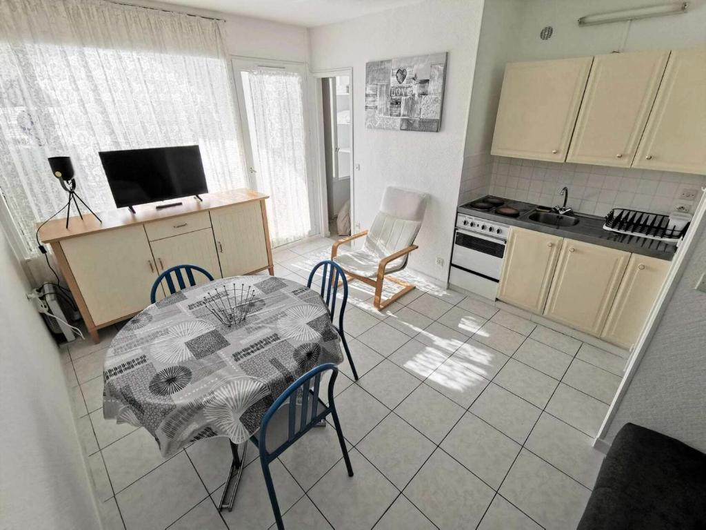 - une cuisine avec une table, une table et des chaises dans l'établissement Résidence Les Terrasses Du Port - 2 Pièces 4 couchages PORT LEUCATE MAE-5514, à Port-Leucate