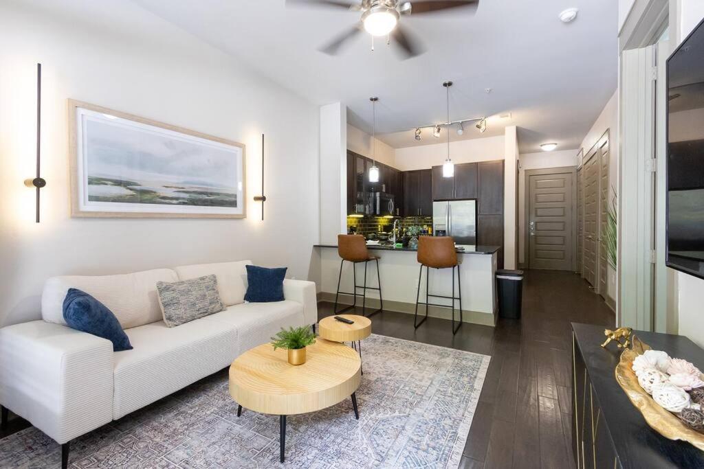 - un salon avec un canapé blanc et une table dans l'établissement Luxury Downtown Houston Suite, à Houston
