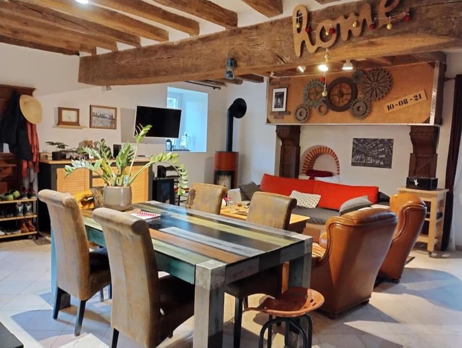 comedor con mesa y sillas en Longère de charme au calme de sa campagne environnante, en Marigné-Laillé