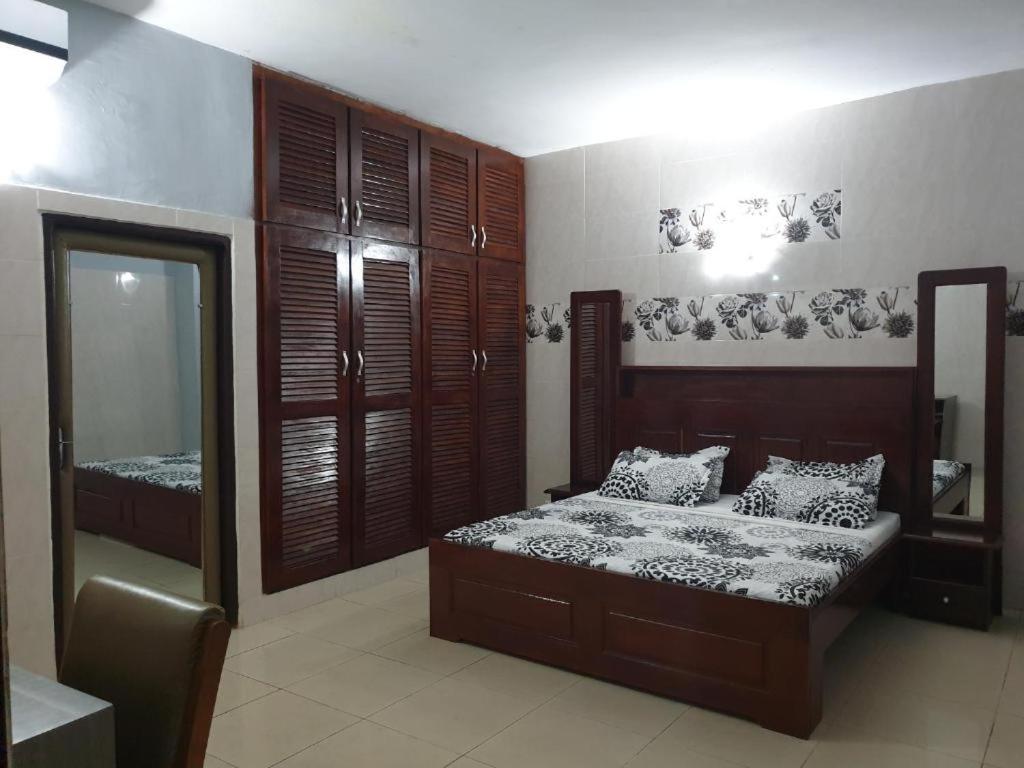 a bedroom with a bed and a mirror at Hôtel Résidence Georges Colette in Yopougon