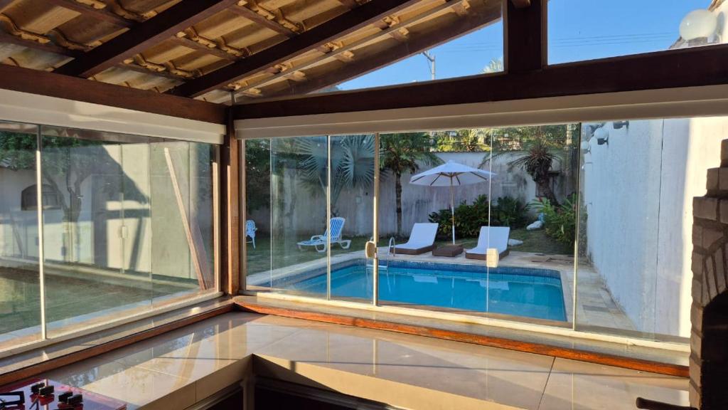 a room with a view of a swimming pool through windows at Aldeia Maravista in Niterói