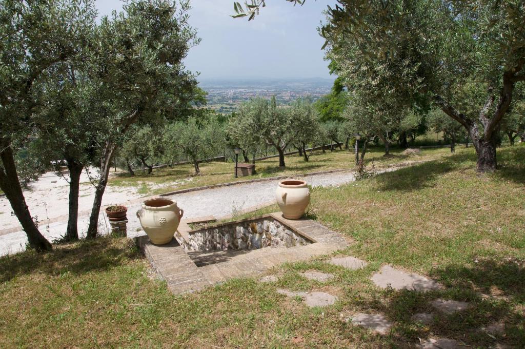 a garden with two large vases sitting on a hill at Casa Vacanze L'olivo al Borghettaccio in Assisi