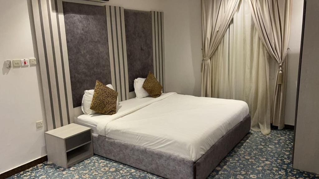1 dormitorio con 1 cama blanca grande y 2 almohadas en اجواء المساء للوحدات السكنيه المفروشه, en Riad