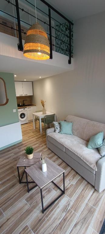 un salon avec un canapé et une table dans l'établissement Le Colibri, à Saint-Jean-de-Monts