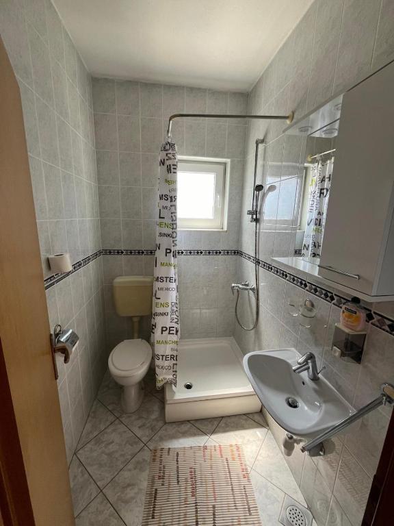 a bathroom with a toilet and a sink at Apartmani Šaldi in Pakoštane