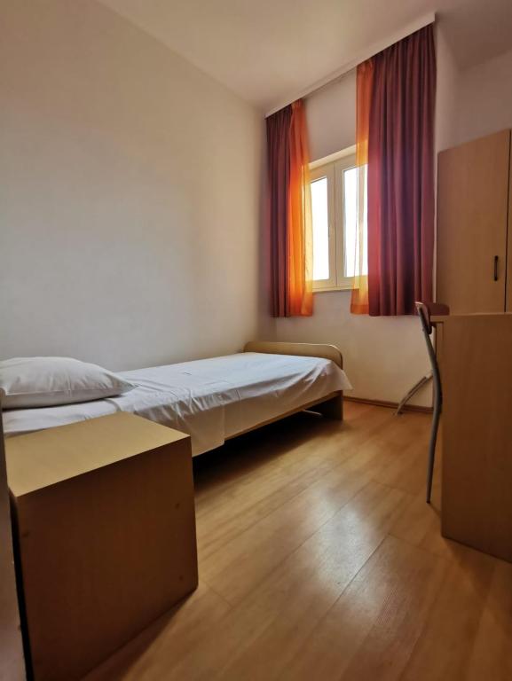 a bedroom with two beds and a window at Apartmani Šaldi in Pakoštane