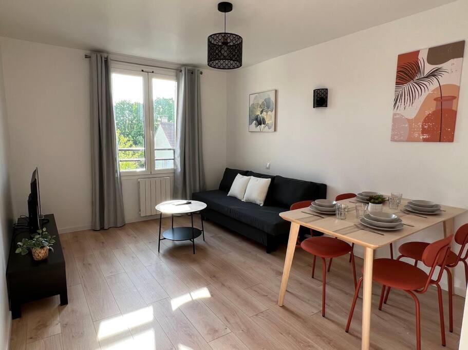 un salon avec une table et un canapé dans l'établissement WD Saint Roch - Appartement 201 - Métro 7 Proche Paris, à Villejuif