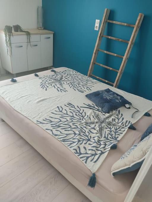 - un lit avec couverture dans une chambre dans l'établissement Appt bord de mer /rez de jardin, à Notre-Dame-de-Monts
