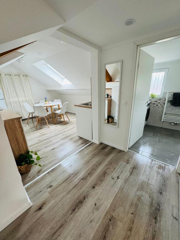 an open living room with wooden floors and a table at Aria apartment in Mošnje