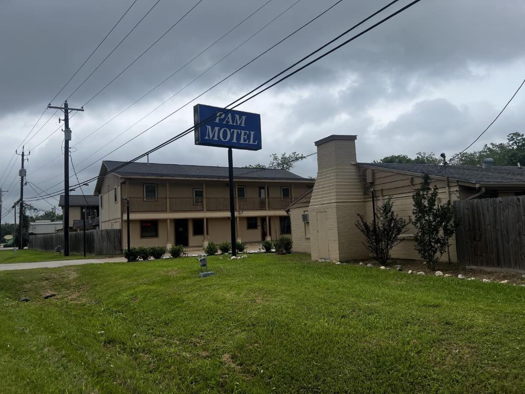 una señal para un motel de granja frente a una casa en Pam Motel Clute Lake Jackson Freeport, en Clute