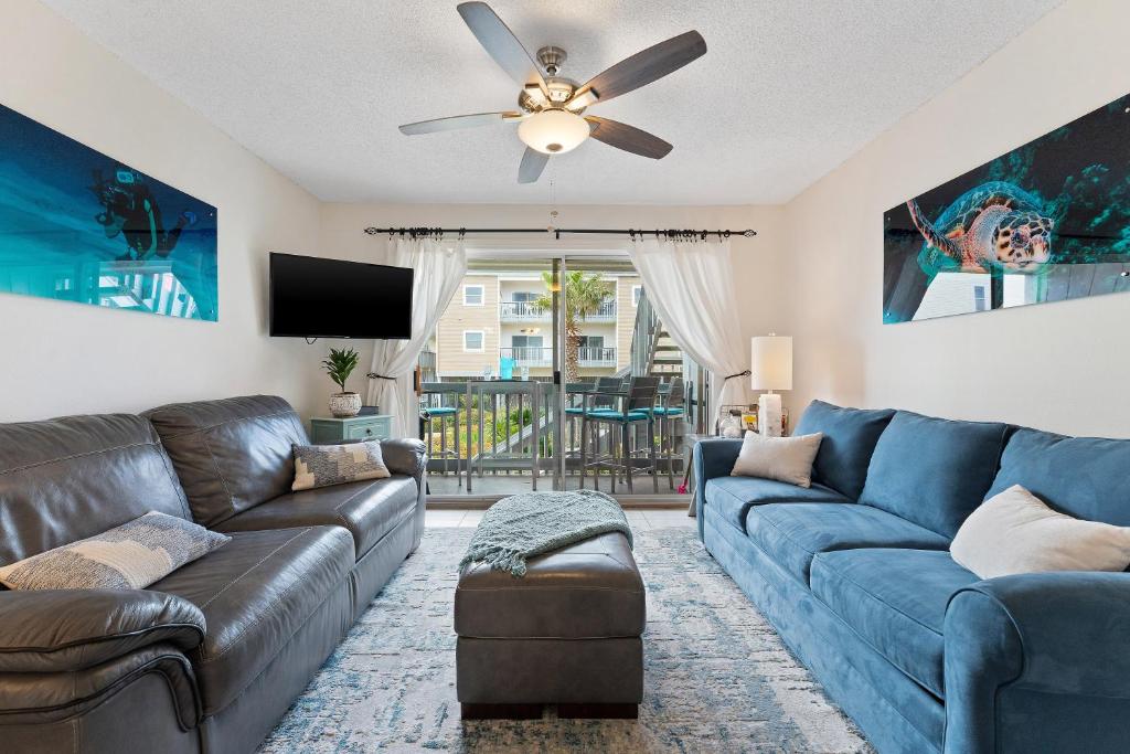 a living room with a couch and a ceiling fan at Villas On The Gulf L1- Ocean view steps to beach! in Pensacola Beach