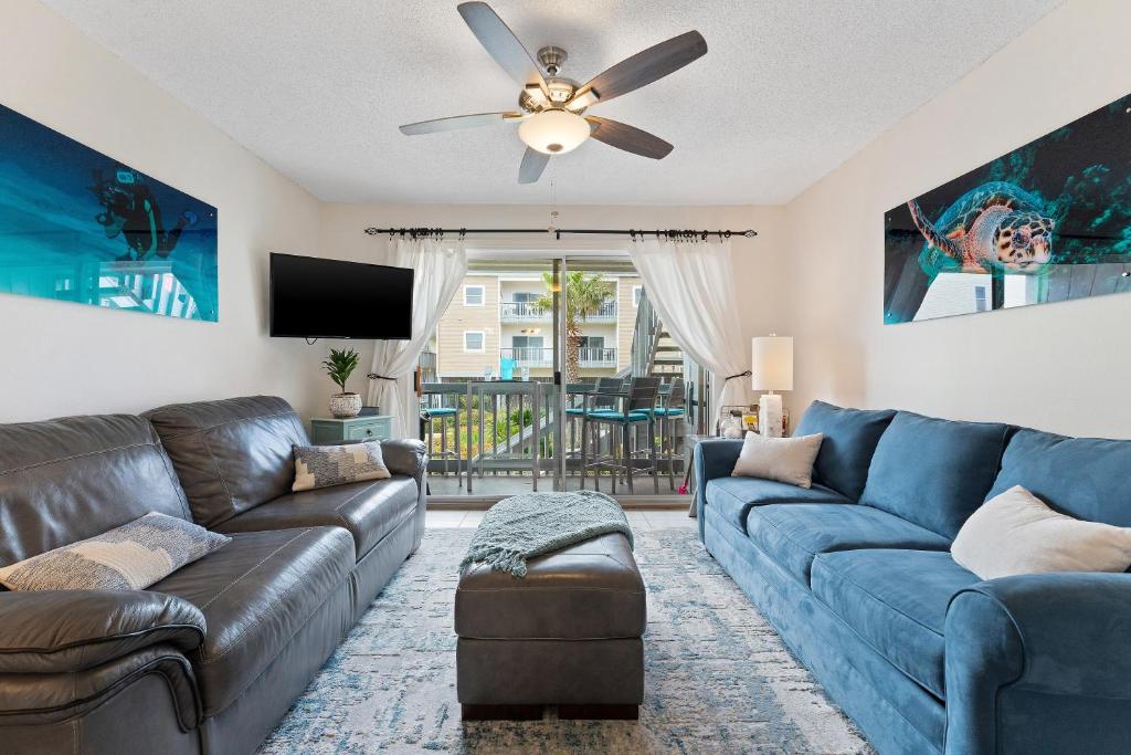 ein Wohnzimmer mit einer Couch und einem Deckenventilator in der Unterkunft Villas On The Gulf L1- Ocean view steps to beach! in Pensacola Beach
