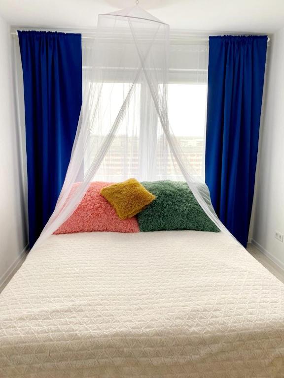 a bed with two pillows in front of a window at Seaview Flat in Liepāja
