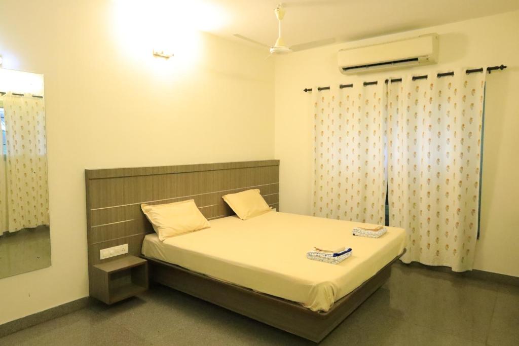 a bedroom with a bed in a room with a window at Transit Nest - Homestay Near Madurai Airport in Madurai