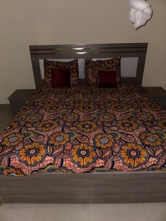 a large bed with a colorful blanket on it at Alpha house in Ndangane