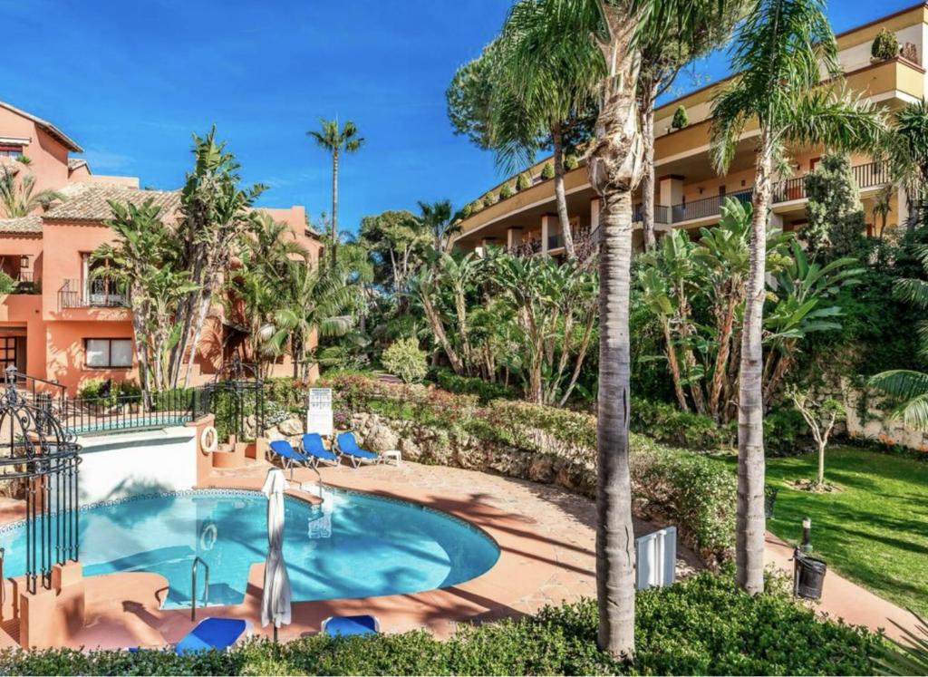 Blick auf den Pool in einem Resort mit Palmen in der Unterkunft Lovely Elviria Apartment 200m from the beach in Marbella